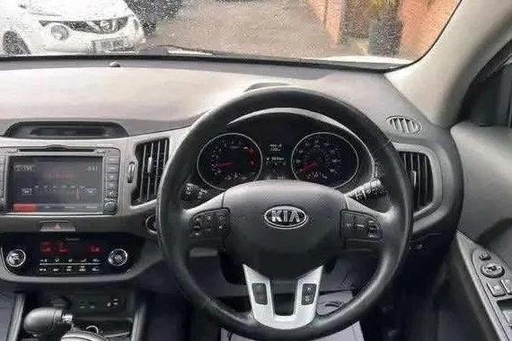 Kia Sportage KX-4 interior showing dashboard, steering wheel and touchscreen navigation
